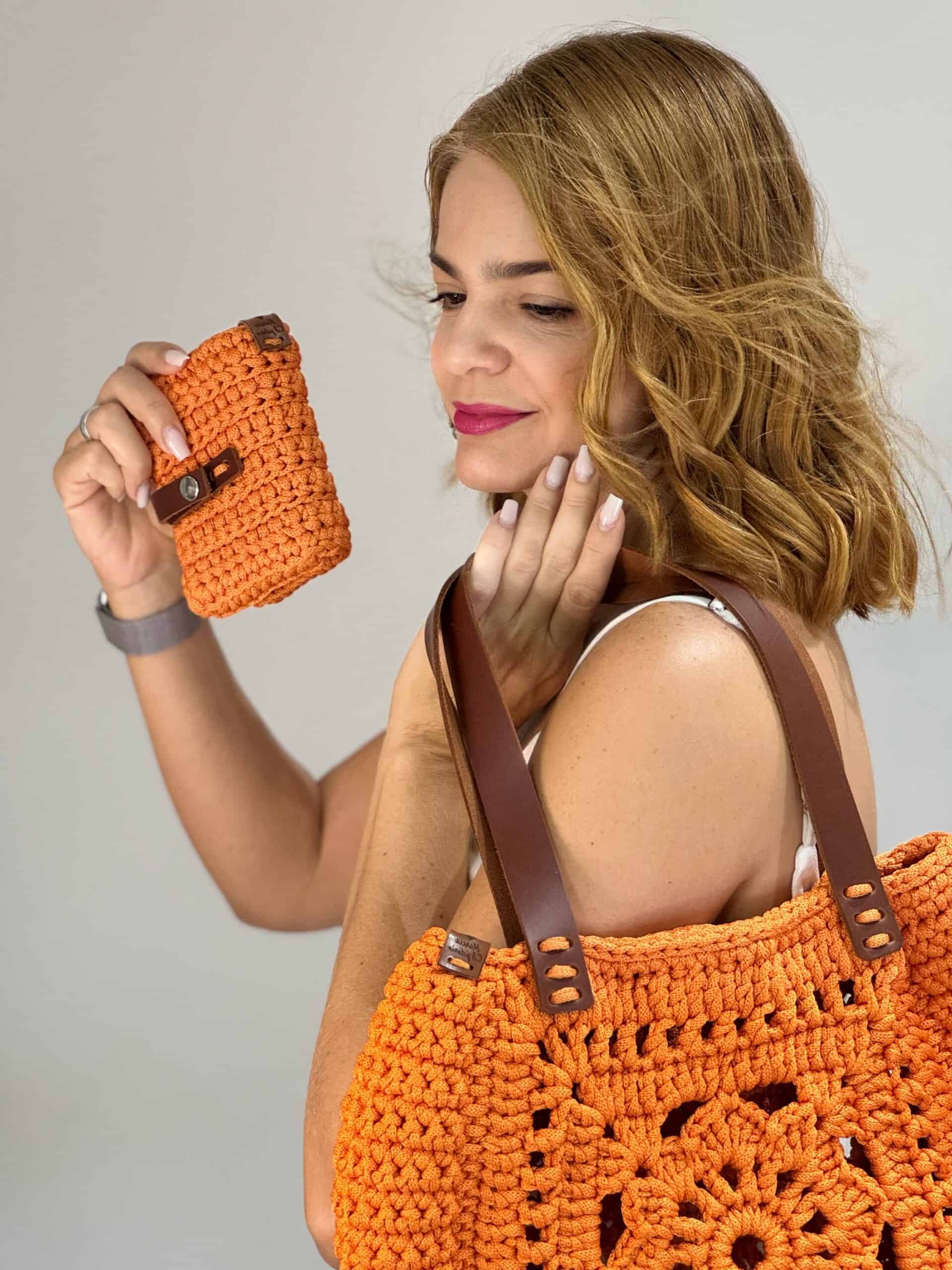Márcia C Izidorio com bolsa de crochê em ambiente elegante